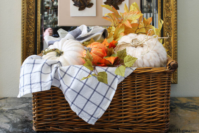 decorative pumpkin with yarn in basket with blue check dishtowels