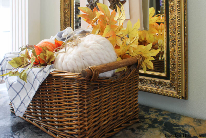 decorative pumpkin with yarn in basket with blue check dishtowels