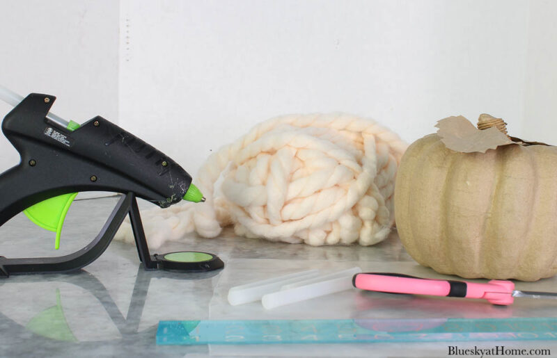 chunky cream yarn with paper maché pumpkins and glue gun