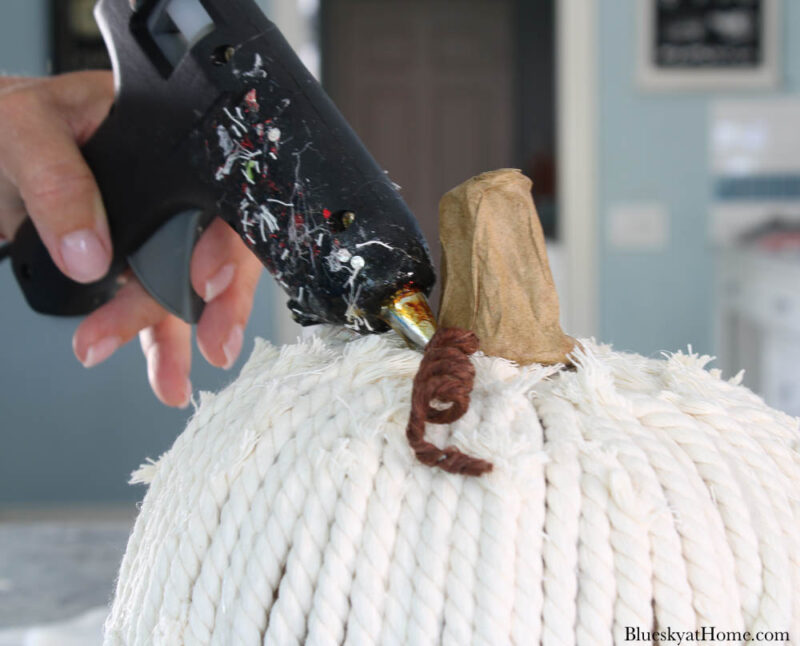 gluing wired grapevine twine to pumpkin