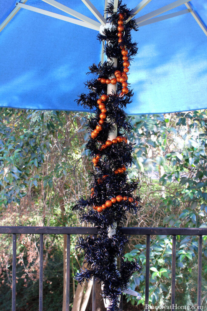 black garland on post with orange beads