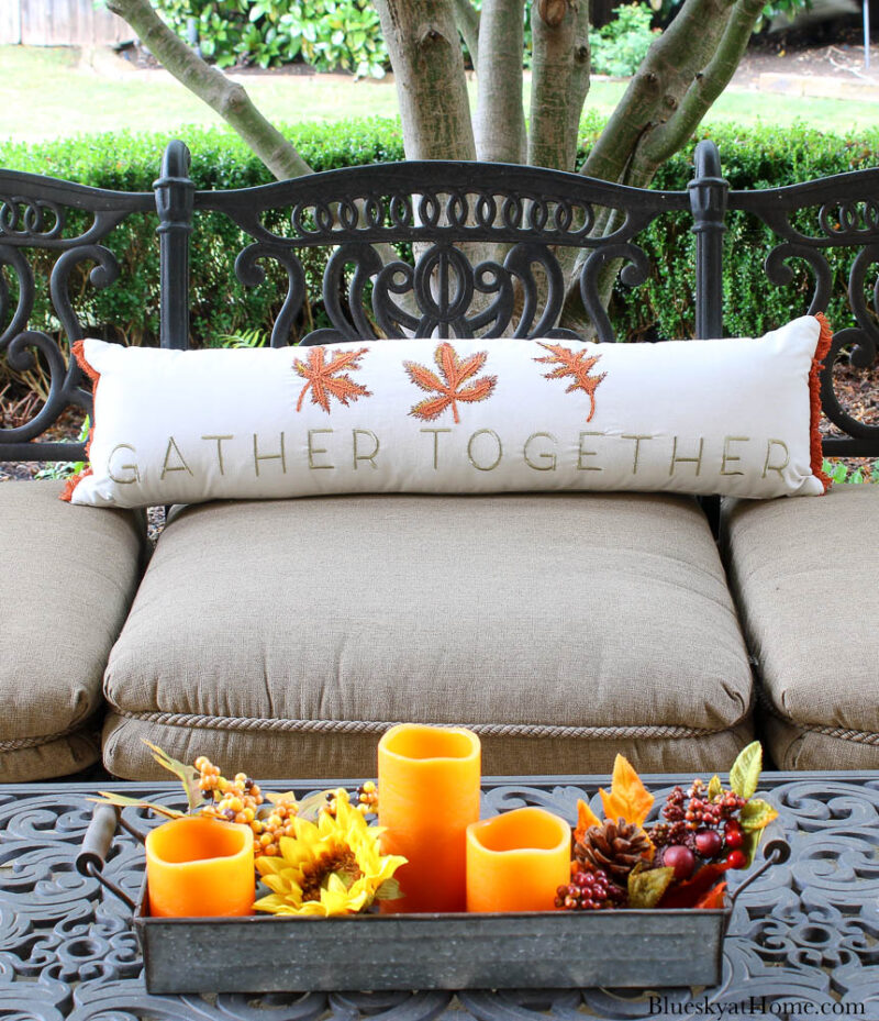 outdoor sofa with pillow and orange candles
