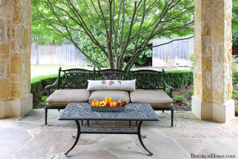 outdoor sofa with pillow and orange candles