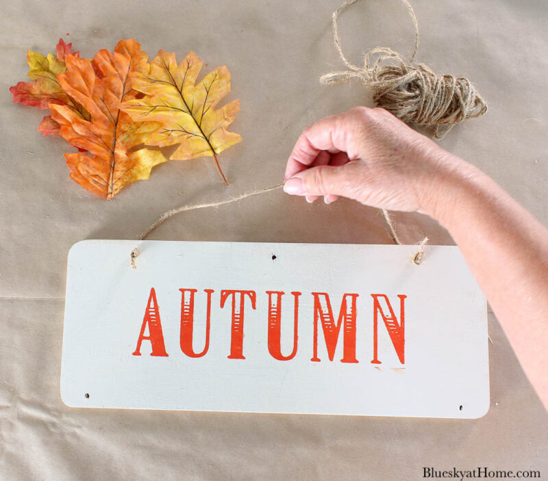 wood sign with word autumn and leaves