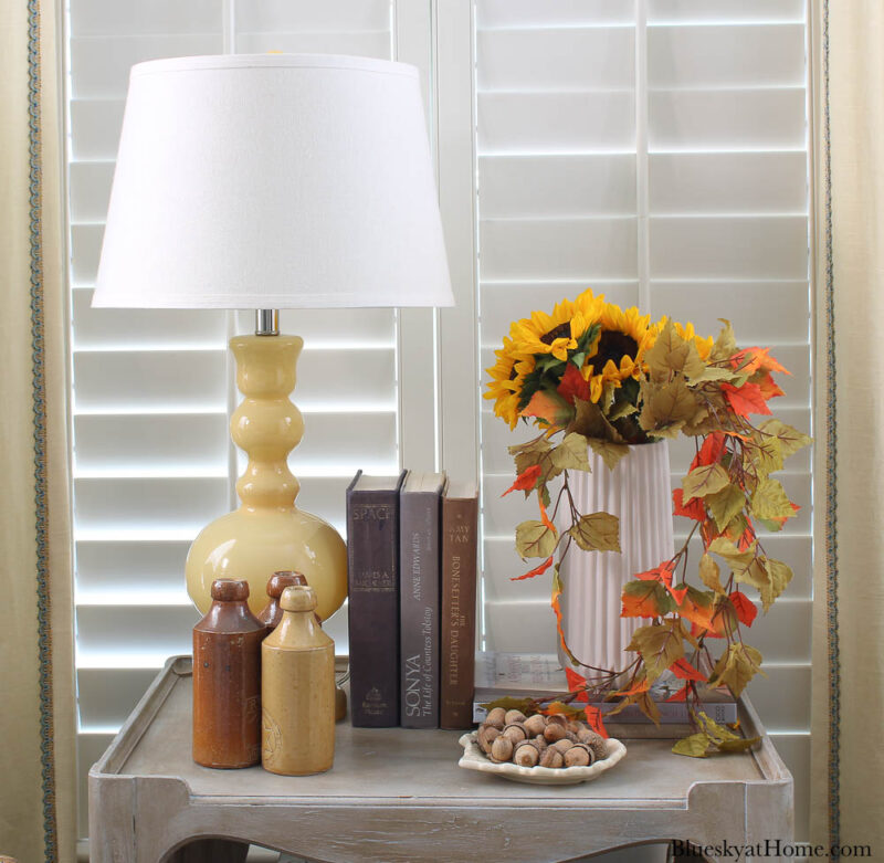 sunflowers and faux fall leaves in white vase on table