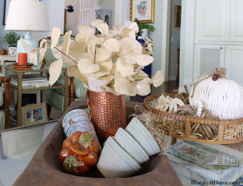 cream colored fall leaves in a copper pitcher