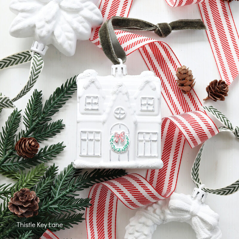 white Christmas ornament on red stripe ribbon