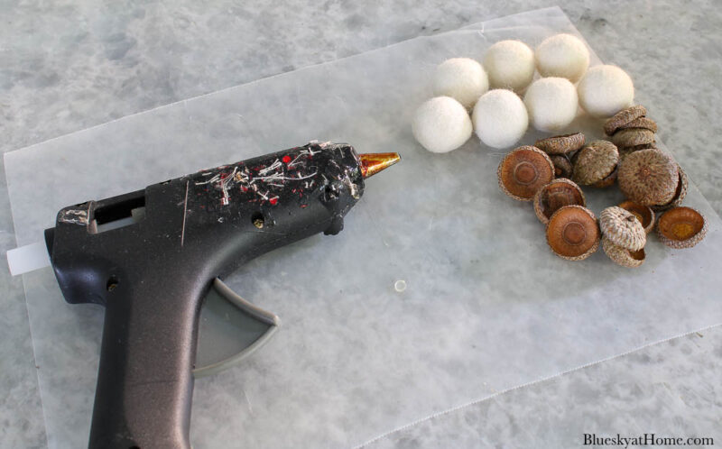 glue gun with white felt balls and acorn tops