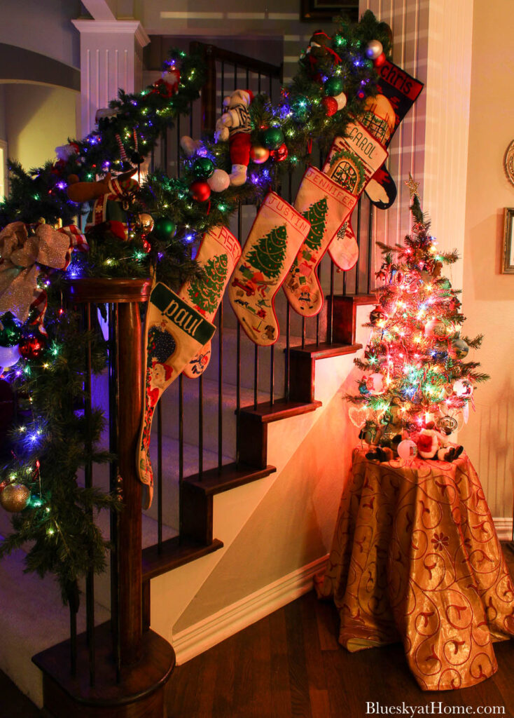 lighted Christmas staircase and Christmas tree on table