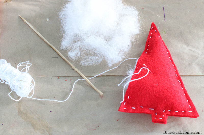 stuffing batting into red felt Christmas trees