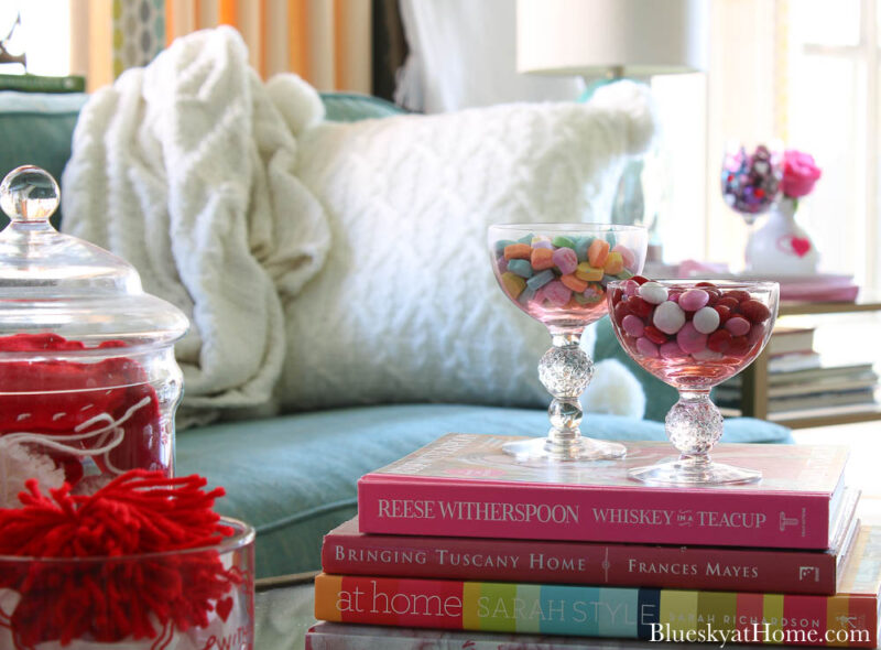 pink glasses with candy on books