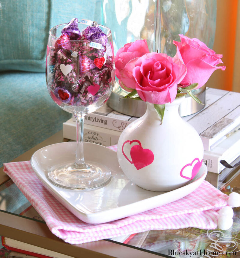 pink roses in vase and candy in wine glass