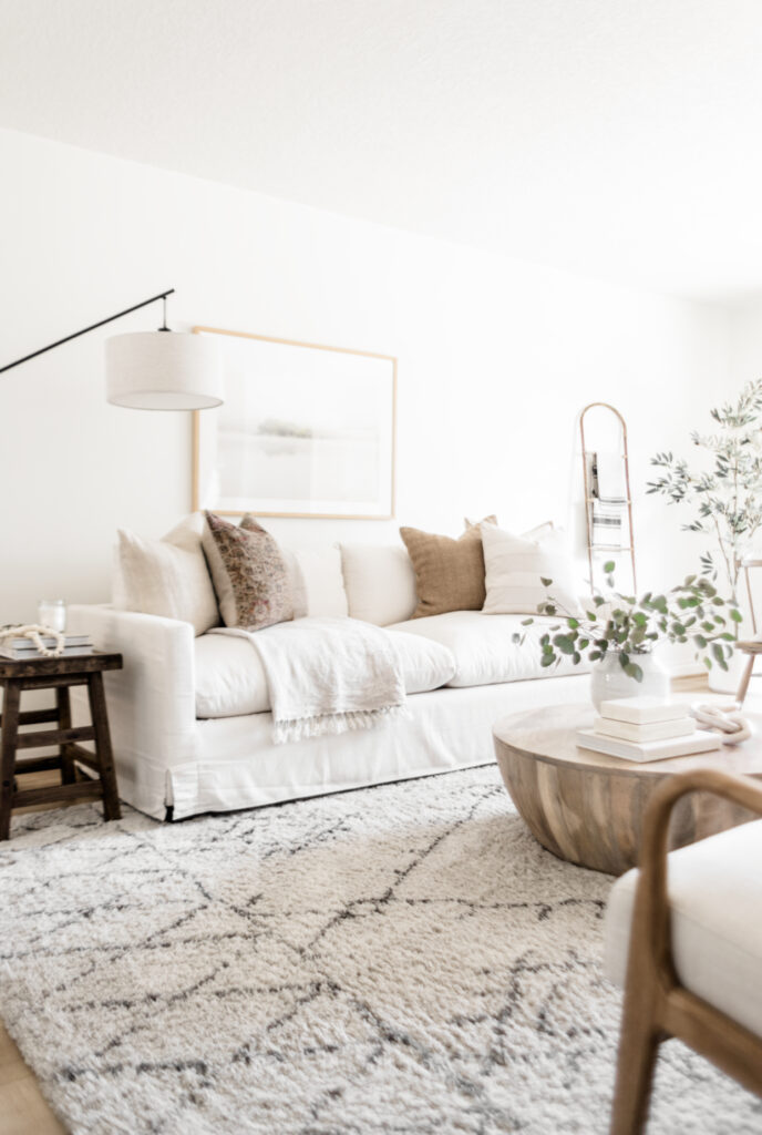 white sofa with neutrla pillows and wood coffee table