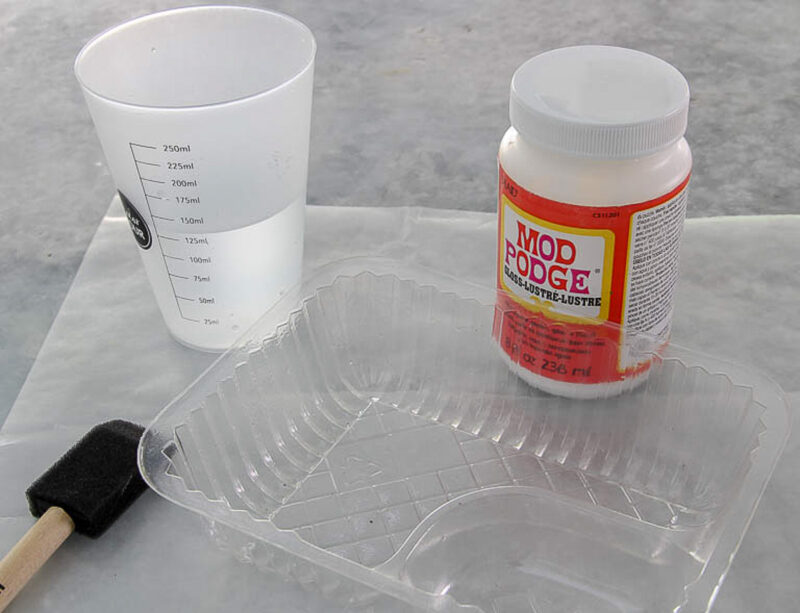 bottle of Mod Podge and cup of water