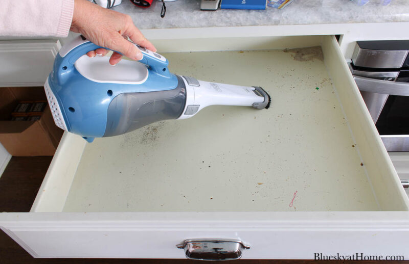 using dust buster to clean drawers