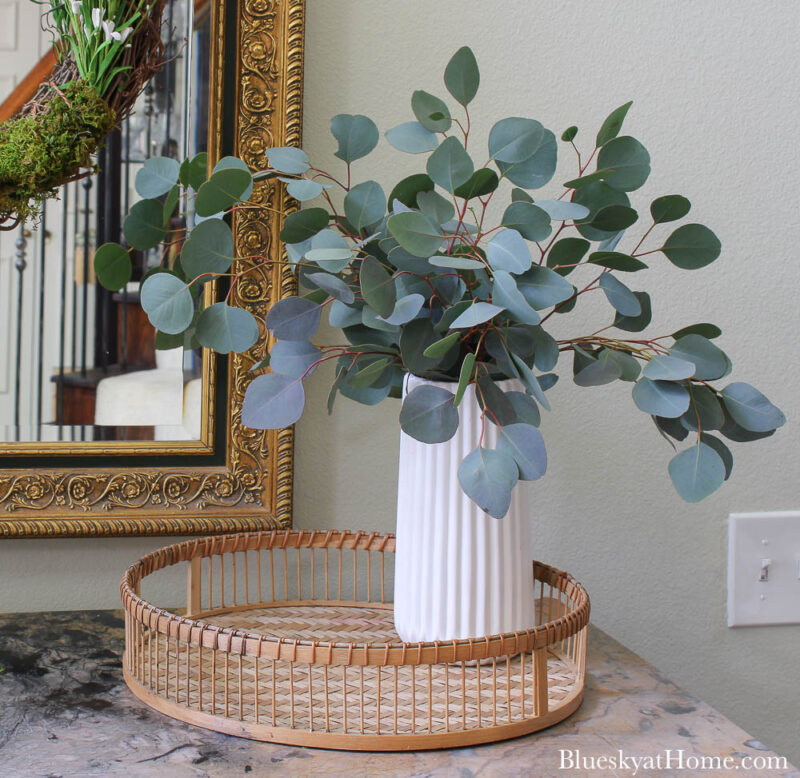 white vase with greenery on tray