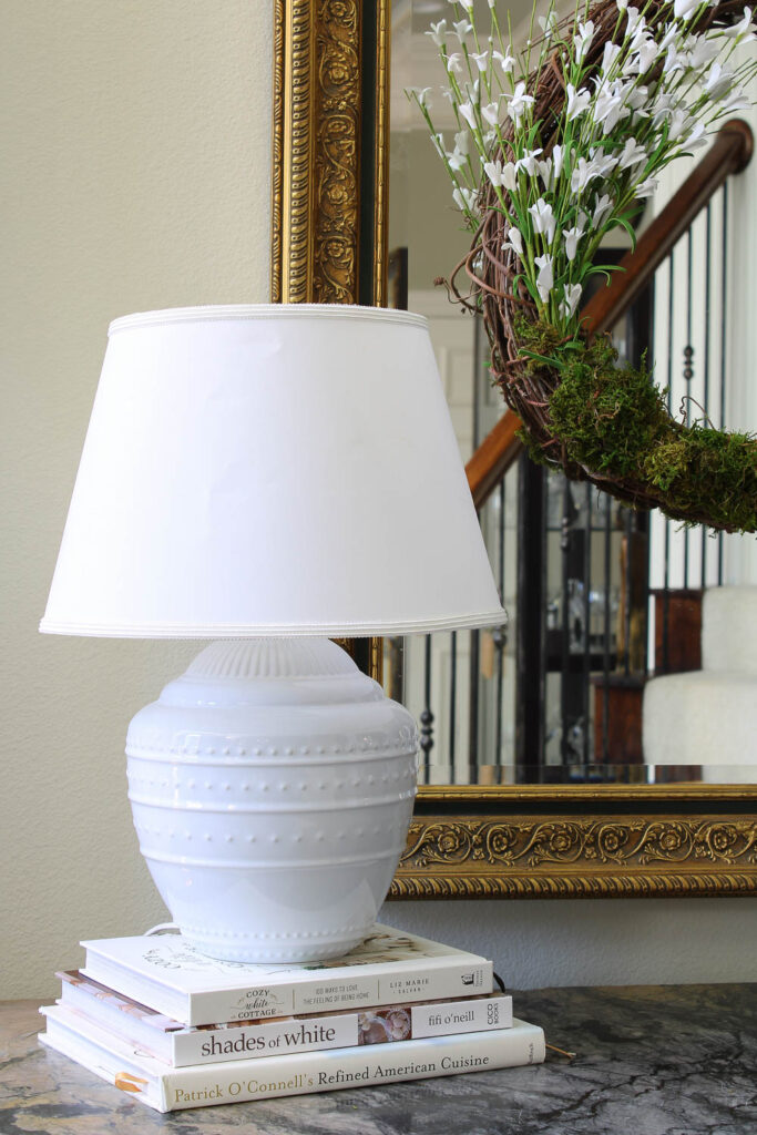 white lamp on stack of white books