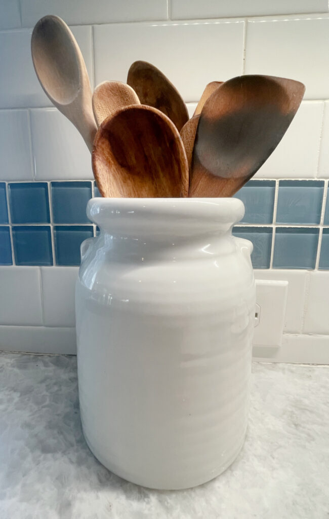 white crock filled with wooden spoons