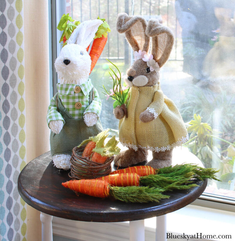 Easter bunnies with next and carrots on table