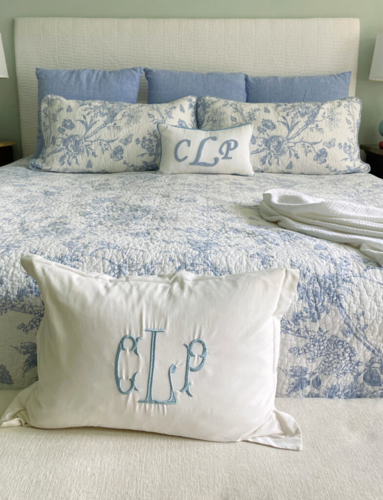 blue and white coverlet with blue Euro shams on king bed
