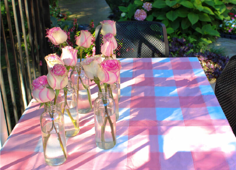 pink checked tablecloth with bottles of pink flowers