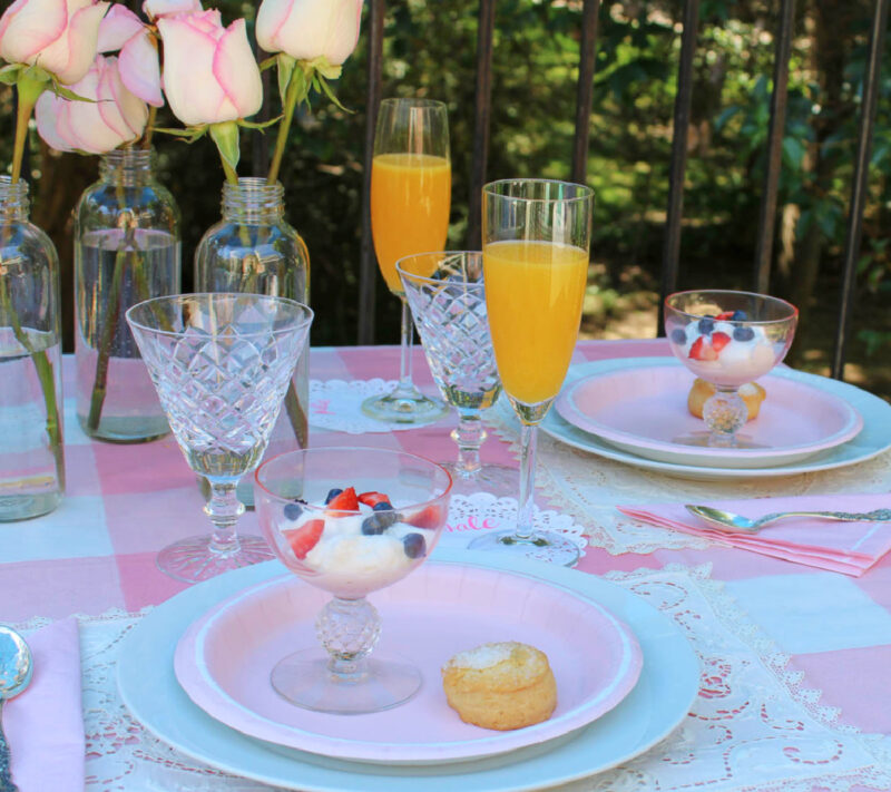 orange juice mimosas on pink summer table setting