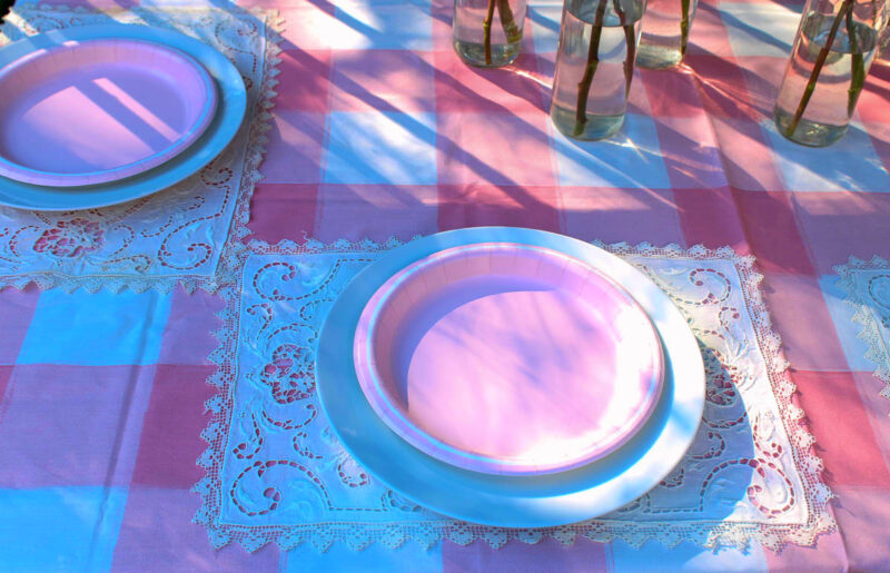 pink roses in bottles on pink table setting