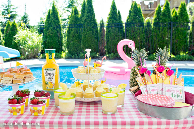 food set up by swimming pool with flamingo in the background