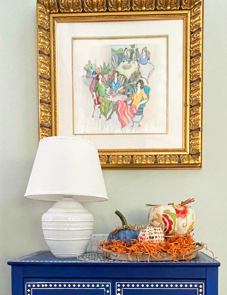 fabric pumpkins on white stands on blue cabinet