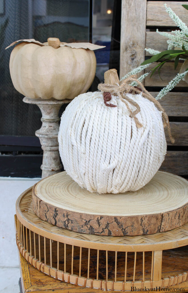 white yarn pumpkin on wood slice
