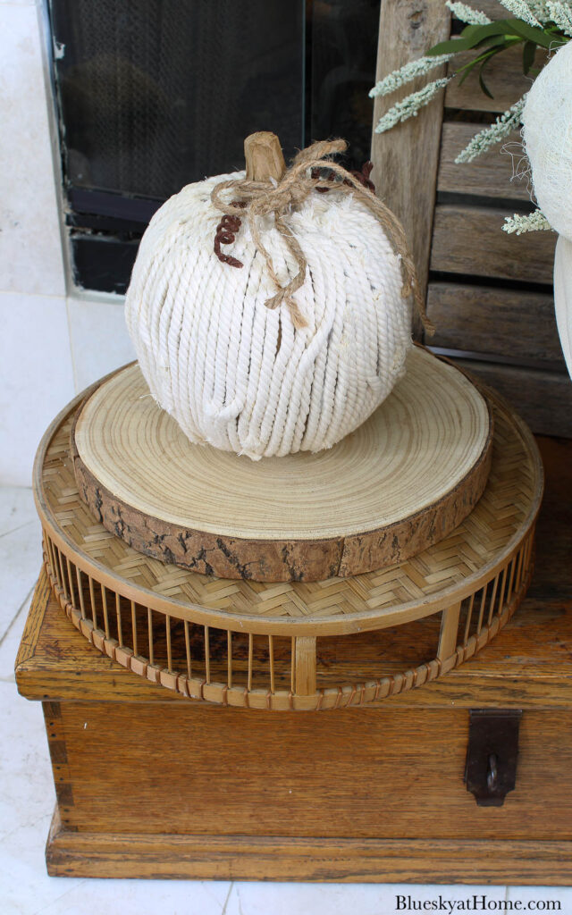 white yarn pumpkin on wood slice