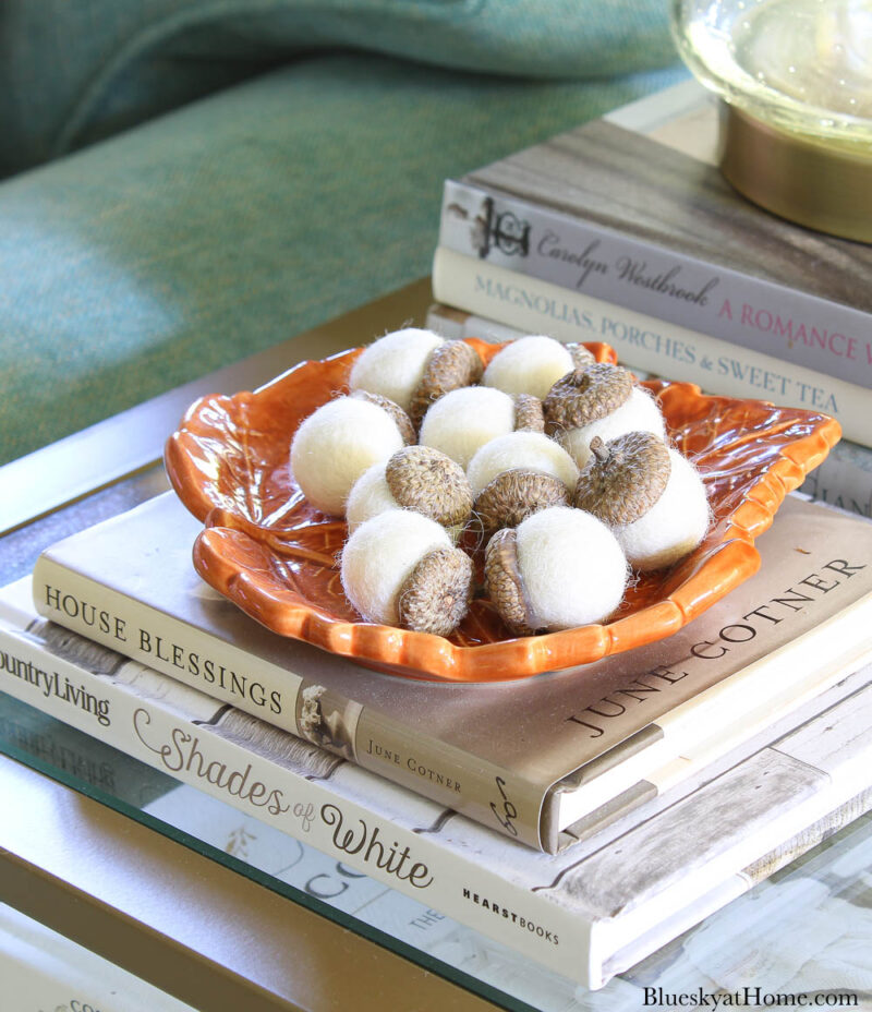 white felt acorns on an orange dish