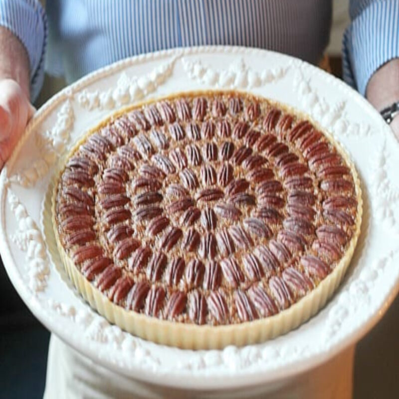 pecan rum tart on white platter