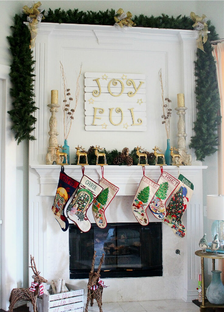 white mantel with greenery on the mantel with stockings