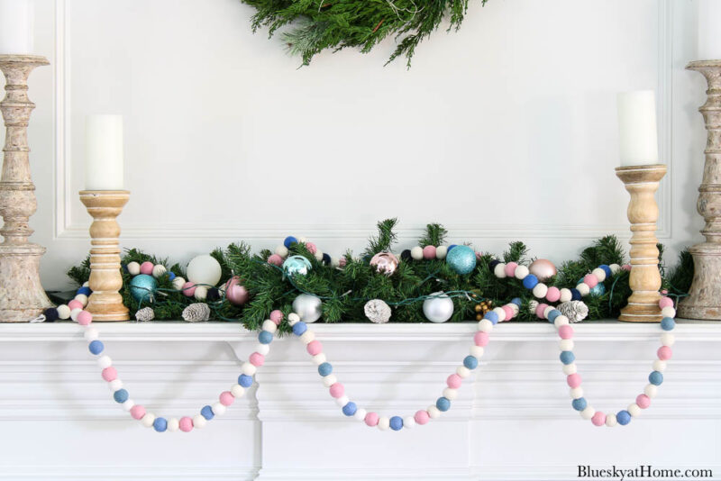 pink and blue felt ball garland on Christmas mantel