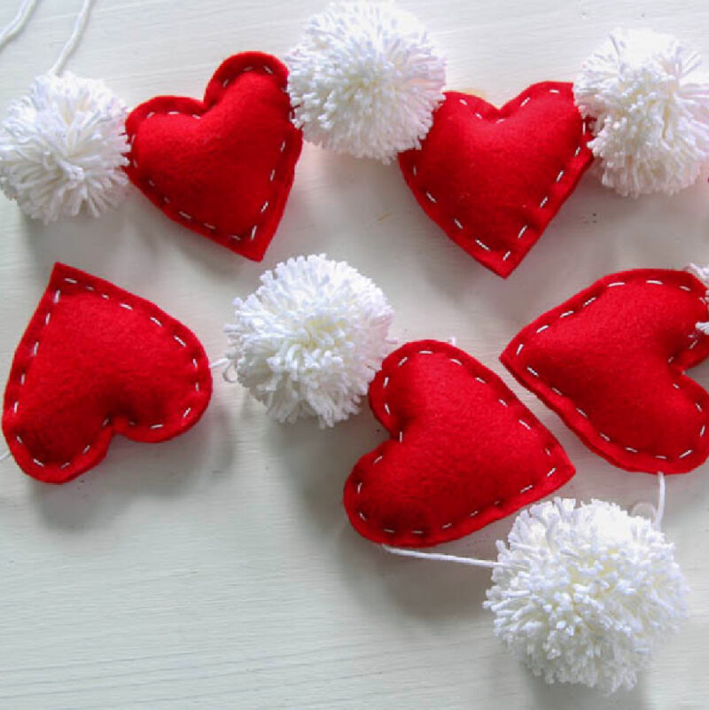 red felt hearts and white yearn pom-poms