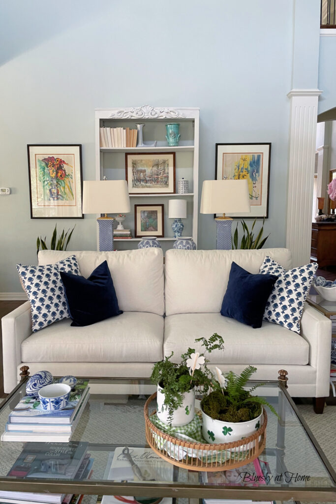 living room sofa with blue pillows and tbles