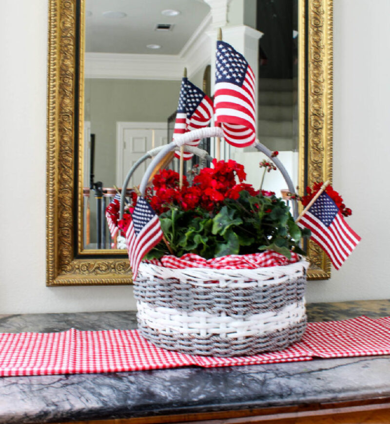 idea for decorating basket grey and white painted woven basket with handle and red geraniums and American flags