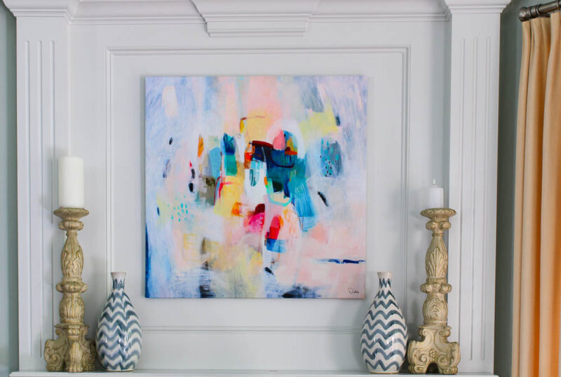 mantel with colorful abstract painting and blue and white vases