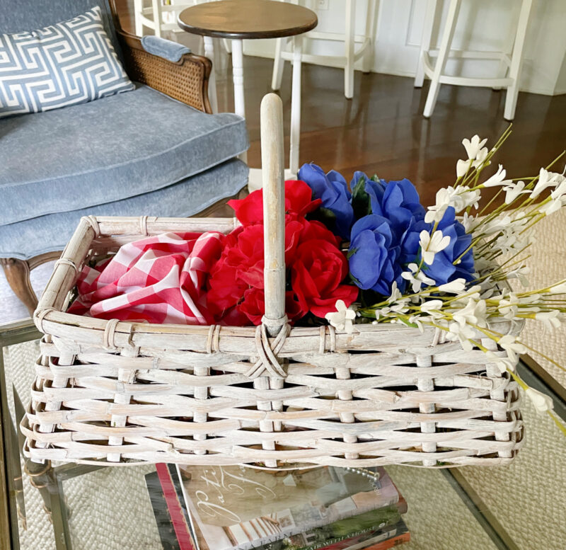idea for decorating baskets  white woven basket with handle filled with red, white, and blue flowers and red and white check cloth