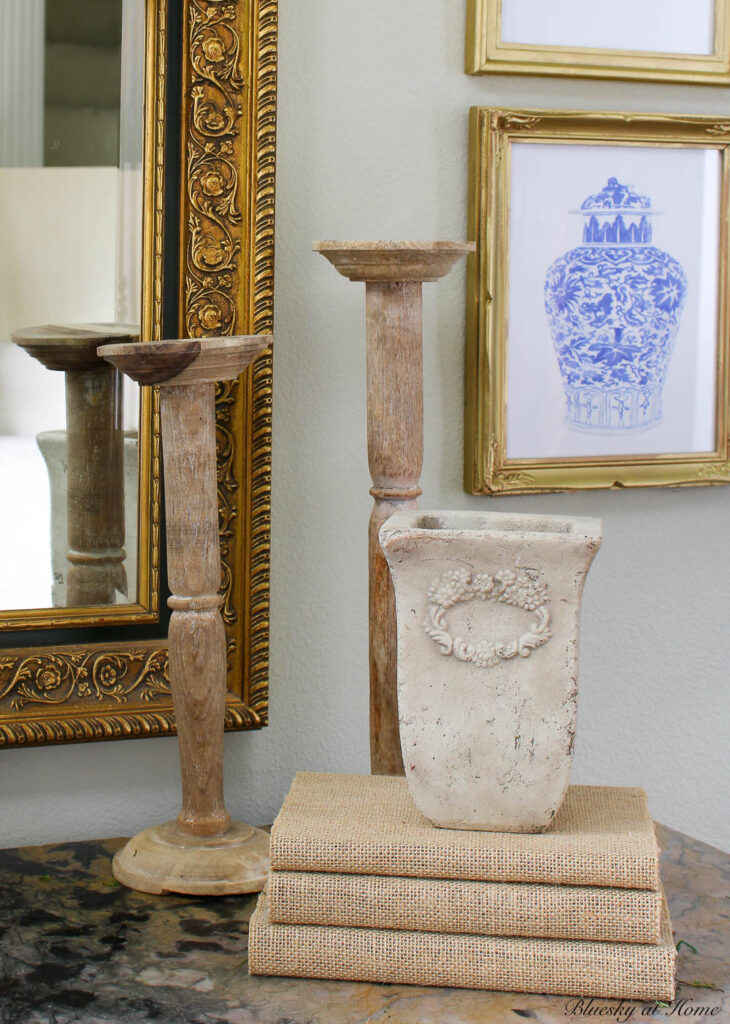 wood candlesticks, stone vase, and burlap books