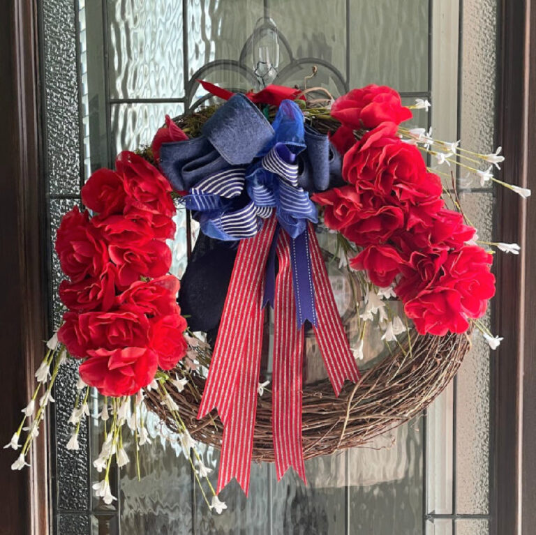 patriotic wreath with red roses and bow on front door