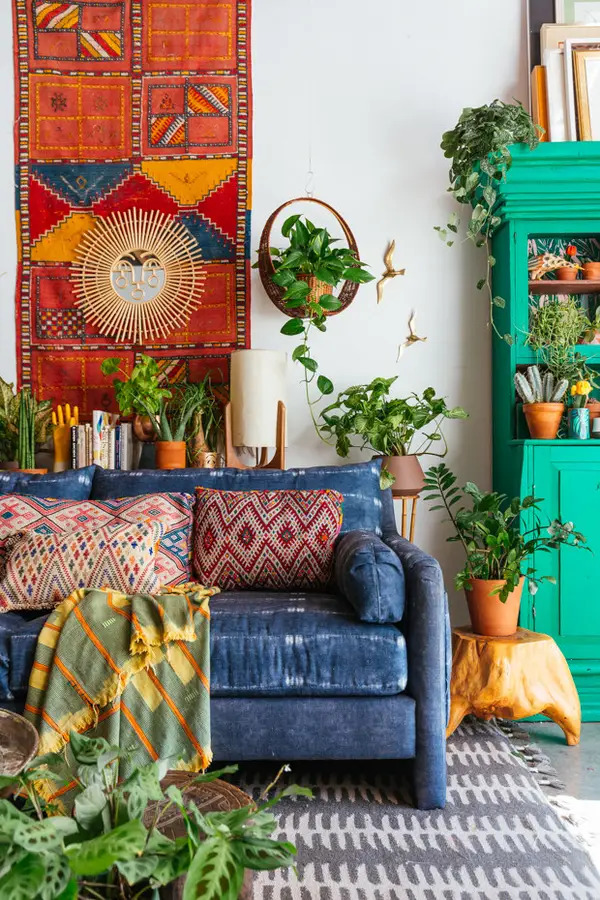 Maximalism home decor with blue sofa and green hutch