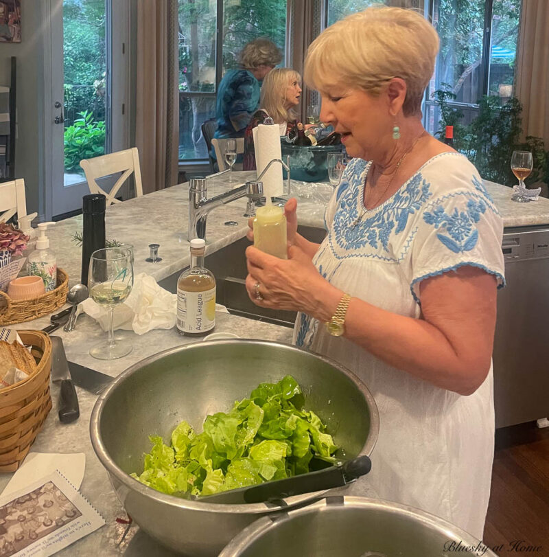 making salad for friends gathered for ladies' dinner party