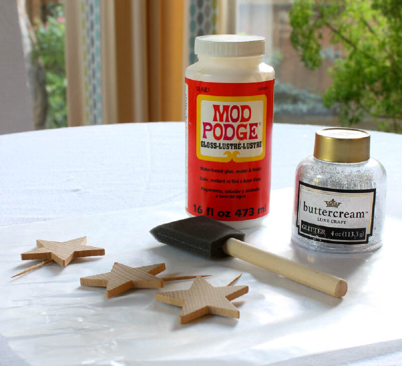 ModPodge with brush, glitter, and wood stars