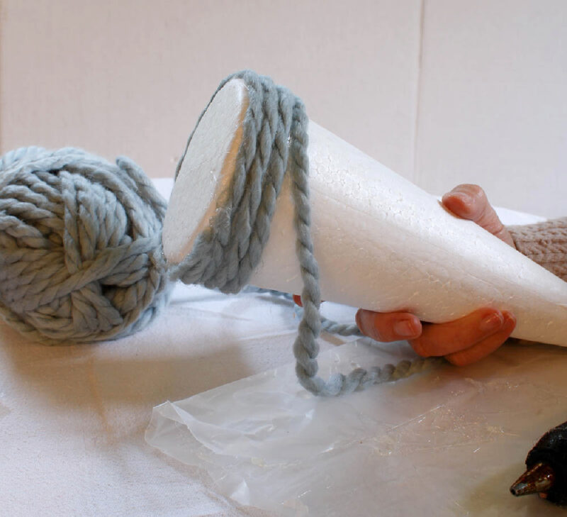 wrapping blue yarn around styrofoam cone