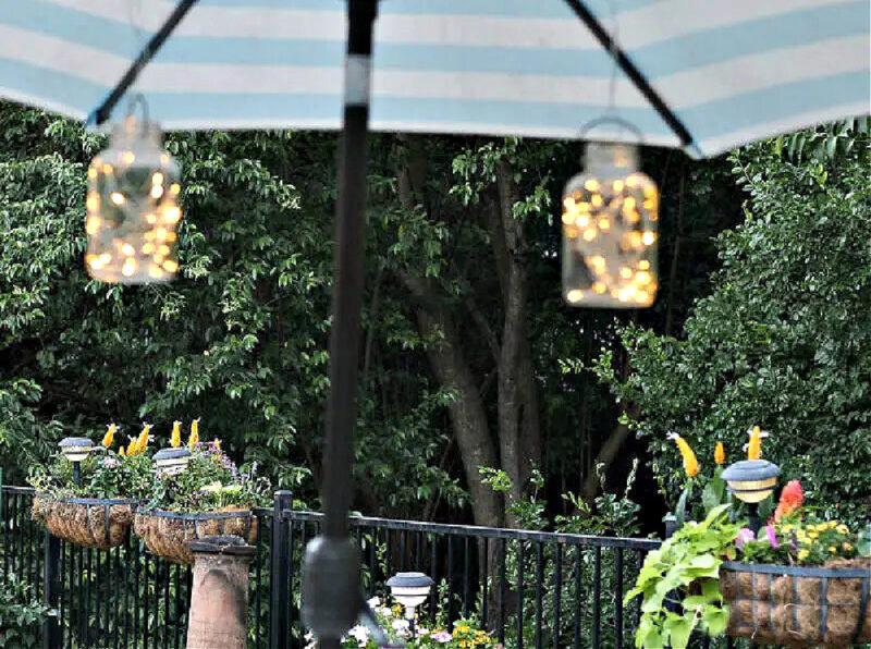 lighted mason jars hanging from outdoor umbrella