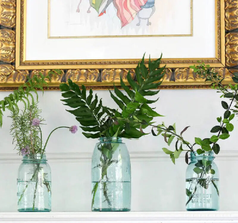 tinted jars on mantel with greenery
