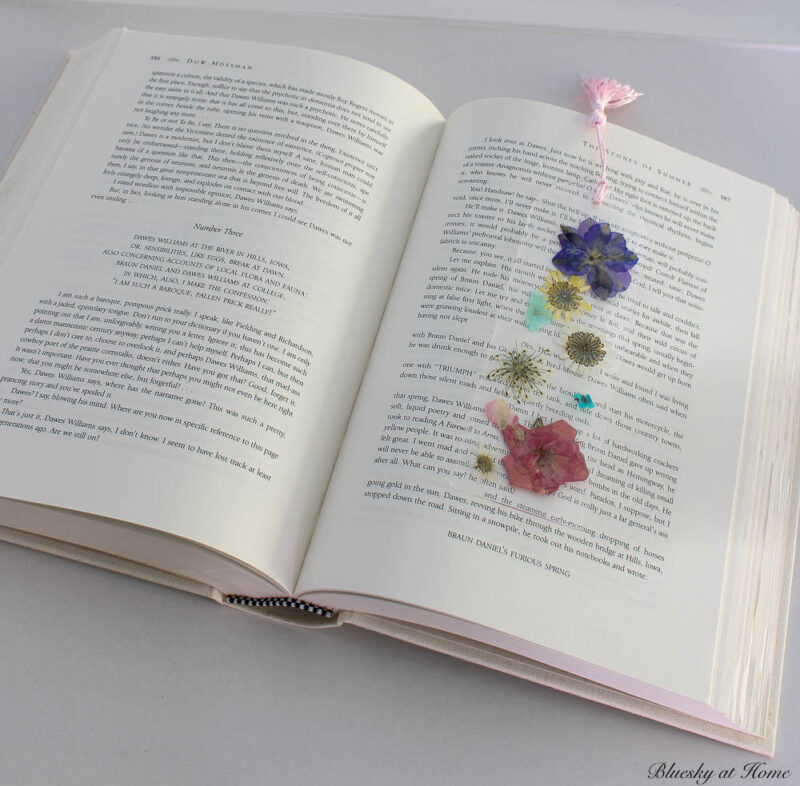 pressed flower bookmark on open book