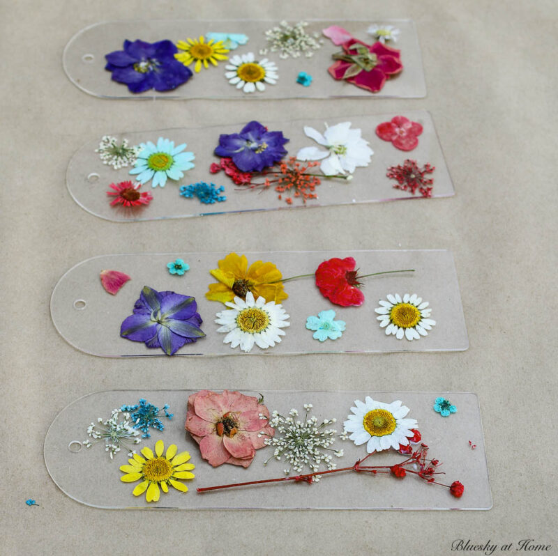 placing dried pressed flowers on plastic bookmarks